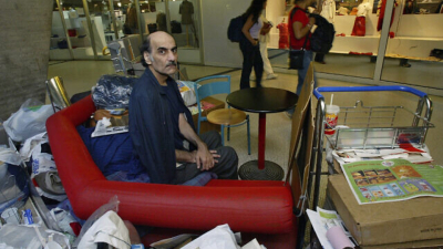 Мерхан Карими Насери седи сред вещите си на Терминал 1