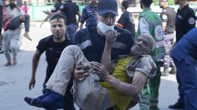 Палестински парамедик носи на ръце свой сънародник ранен при израелски