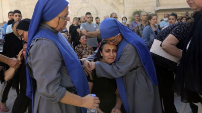 Монахини прегръщат палестинка която скърби за свои роднини убити при
