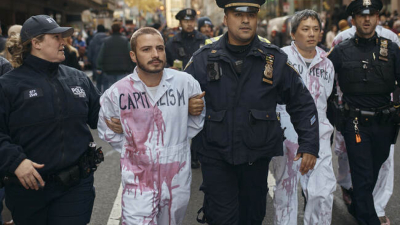 Полицаи отвеждат арестувани пропалестински демонстранти оплискани с фалшива кръв които
