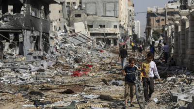 Палестинци вървят през отломки в град Газа след израелски въздушни