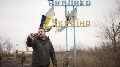 Украинският президент Володимир Зеленски се снима пред табелата на град
