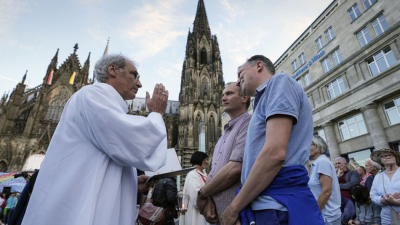 Католически свещеник благославя еднополова двойка по време на масова церемония