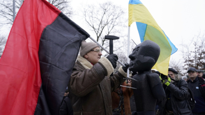 Демонстрант с украинското знаме и флага на Десен сектор забива