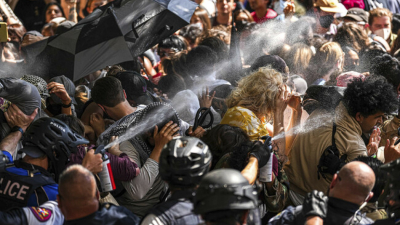 Полицаи пръскат с лютив спрей протестиращи блокирали полицейски автомобили в